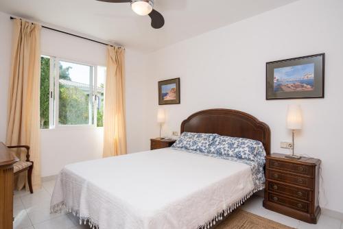 a white bedroom with a bed and a window at Villa Berry in Santa Ponsa