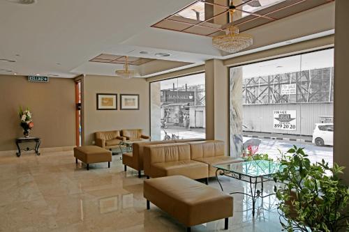 a lobby with a waiting room with chairs and tables at Hotel Malaysia in George Town