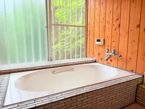 a bath tub in a room with a window at コテージそら豆ん家 in Nasu