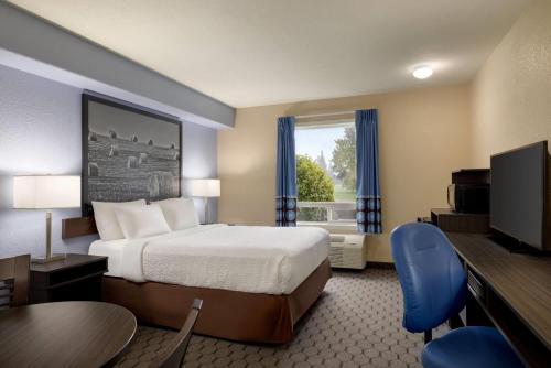 Swan RiverにあるSuper 8 by Wyndham Swan River MBのベッドとテレビがあるホテルの部屋