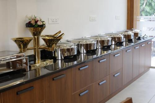 una fila de ollas en un mostrador en una cocina en Eeleem Resorts and Spa, Munnar, en Anachal