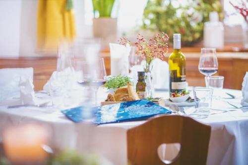 a table with a white table cloth and wine bottles at Gasthof Zur Traube in Neckenmarkt