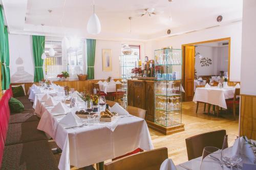 un restaurante con mesas con manteles blancos. en Gasthof Zur Traube, en Neckenmarkt