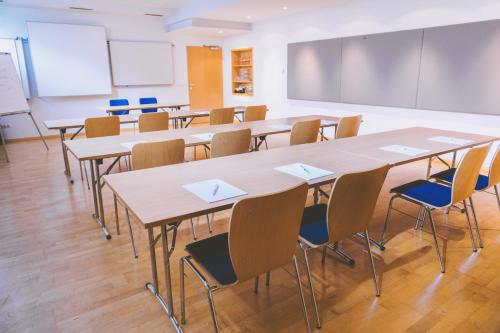 a classroom with tables and chairs and a chalkboard at Gasthof Zur Traube in Neckenmarkt