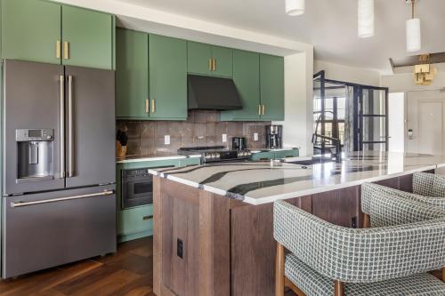 a kitchen with green cabinets and a kitchen island with chairs at Hilton Vacation Club Mill Springs Lodge Pigeon Forge in Pigeon Forge