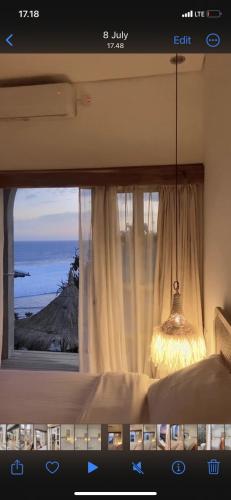 a bedroom with a window with a view of the ocean at Casa Alstonia in Tepus