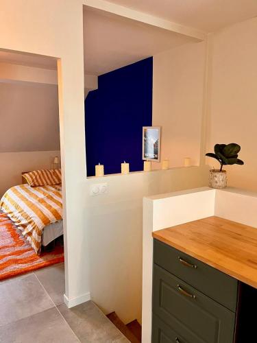 a bedroom with a bed and a blue wall at Charming Studio In Le Mans Chasse Royale in Le Mans