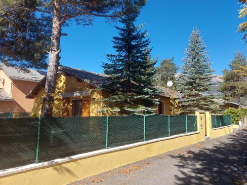 a yellow fence in front of a house at Chalet 126 m² PRALOUP in Uvernet-Fours