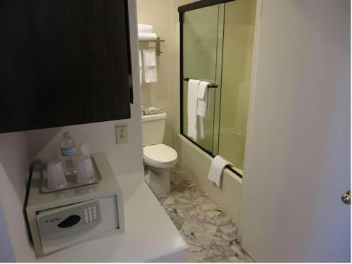 a bathroom with a toilet and a glass shower at Hilgard House Westwood Village in Los Angeles