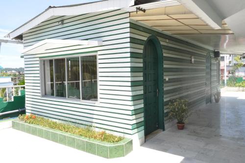 a house with a green door on the side of it at Saikia Nest the Home-stay in Guwahati