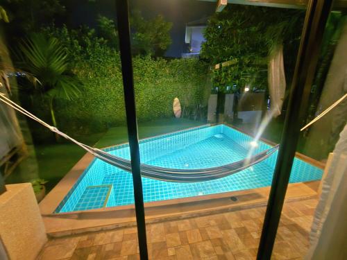 Ban Bang LaにあるPrivate Pool & Cinema Houseの建物の隣にスイミングプール(ハンモック付)