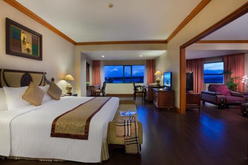 a hotel room with a large bed and a living room at Halong Plaza Hotel in Ha Long