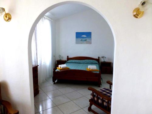 an archway in a bedroom with a bed in it at Villa Casanova in Santa Margherita di Pula