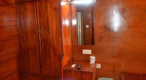 a bathroom with a wooden cabinet and a mirror at Silver Beach Hotel in Trincomalee