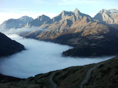 a view of a mountain range with clouds in a valley at B&B Monte Giove Formazza in Formazza