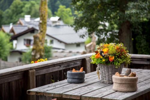 a wooden table with two baskets and flowers on a balcony at Buccara Apartments Kitzbühel in Kitzbühel