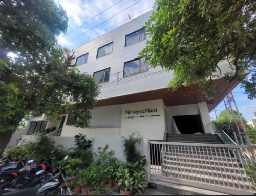 a white building with motorcycles parked in front of it at Hotel Nirvana Nest in Lucknow