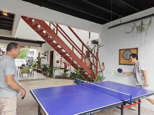 two men standing around a ping pong table at 玖月舒苑 in Sibu