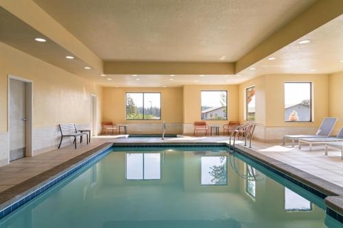 a pool in a house with chairs and tables at Hampton Inn & Suites Whitefish in Whitefish
