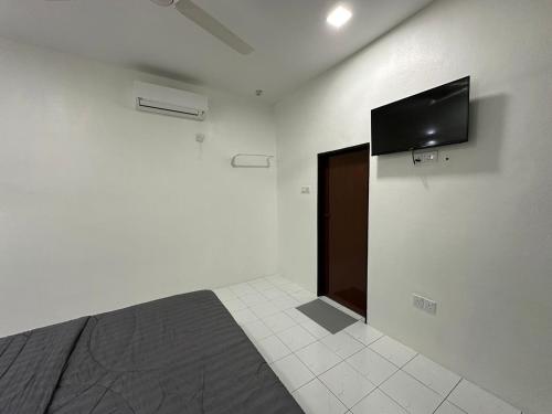 une chambre avec un lit et une télévision à écran plat sur un mur dans l'établissement cheta roomstay, à Gua Sai