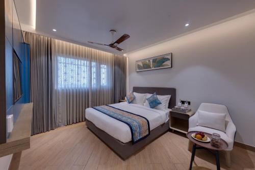 a hotel room with a bed and a chair at Ira by Orchid Dwarka in Dwarka