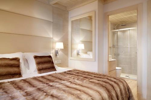 バケイラ・ベレットにあるVal de Ruda Luxe 41 by FeelFree Rentalsのベッドルーム(大型ベッド1台付)、バスルームが備わります。