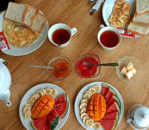 una mesa con platos de comida y tazas de té en Hill house guest, en Mirissa