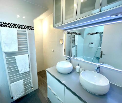 Ideally located , Eiffel Tower view في نويي سور سين: حمام به حوضان أبيضان ومرآة
