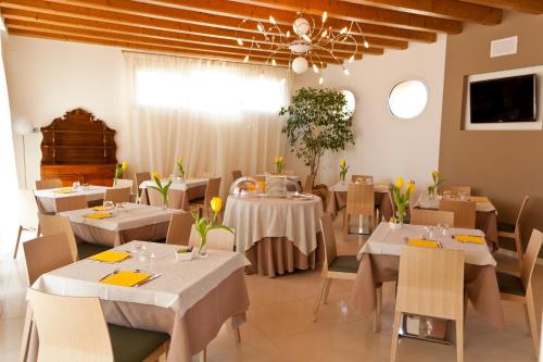 ein Restaurant mit weißen Tischen und Stühlen und einer Decke in der Unterkunft Agriturismo Ca' Beatrice - Venice Airport in Favaro Veneto