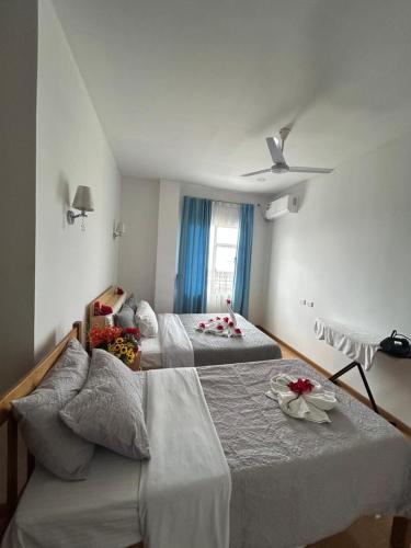 a bedroom with two beds and a ceiling fan at TR Apartment in Honiara