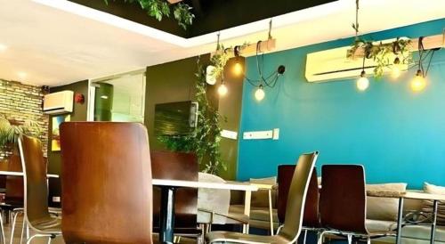 a dining room with tables and chairs and a blue wall at Casuarina Hotel in Kota Kinabalu