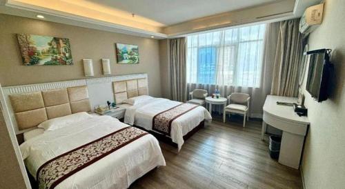 pokój hotelowy z dwoma łóżkami i umywalką w obiekcie GreenTree Inn Guangdong Huizhou Chenjiang Intercity Rail Station Business Hotel w mieście Huizhou