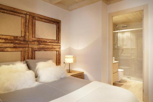 1 dormitorio con 1 cama con almohadas blancas y baño en Val de Ruda Luxe 42 by FeelFree Rentals, en Baqueira Beret