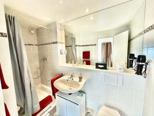 a white bathroom with a sink and a shower at Altstadtfreude Stralsund in Stralsund