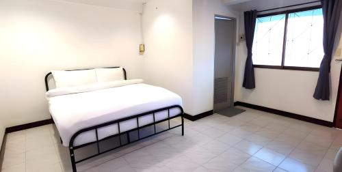 a bedroom with a bed with white sheets and a window at GO INN Patong Beach Phuket - โกอินน์ ป่าตอง Pro in Patong Beach