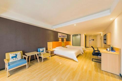 a large hotel room with a bed and chairs at 7Days Premium Chongqing Jiangbei International Airport Rongchuang in Chongqing