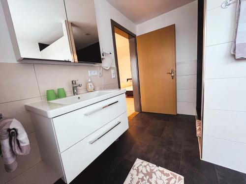 Un baño blanco con lavabo y espejo. en Gasthof Söll, 