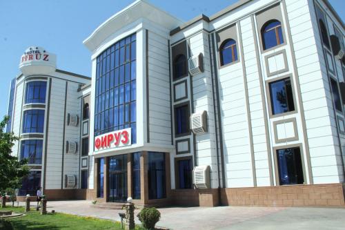 a large white building with a sign on it at Firuz Hotel in Khujand