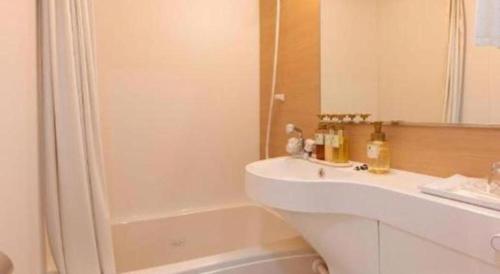a bathroom with a white sink and a shower at Kyoto Plaza Hotel Kyoto Station South in Kyoto