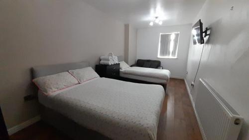 a small bedroom with two beds and a window at Rusholme Rooms in Manchester