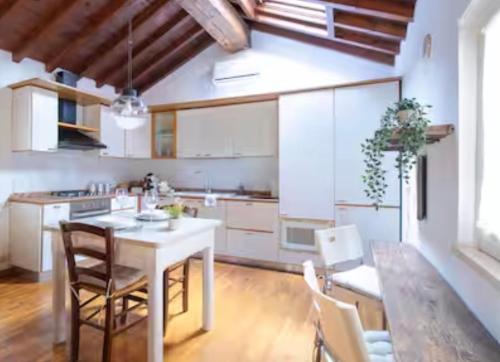 a kitchen with a table and chairs in a room at Loft Santa Anastasia - Piazza delle Erbe in Verona