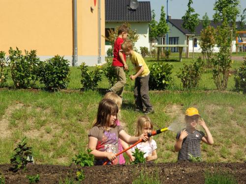 eine Gruppe von Kindern, die im Hof mit einem Gartenschlauch spielen in der Unterkunft Holiday home in Markkleeberg near a lake in Markkleeberg