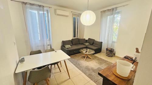 a living room with a couch and a table at Chambre d hotes Marseille Prado in Marseille