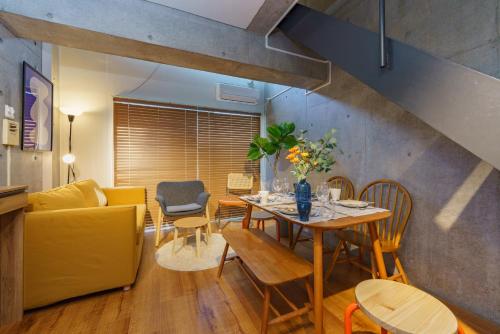 a living room with a table and a yellow couch at Central Nagoya! 15 min from Sta 2 Beds Max7 Family in Nagoya