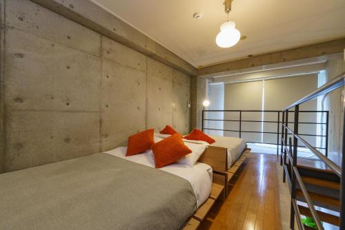 two beds with orange pillows in a room at Central Nagoya! 15 min from Sta 2 Beds Max7 Family in Nagoya