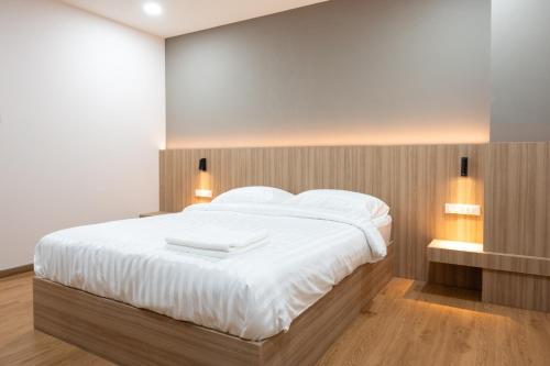 a bedroom with a large bed with white sheets and pillows at Timber Hotel in Ban Bang Rathuk