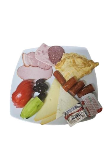 un plato de comida con diferentes tipos de carne y hortalizas en Pensiunea Alex, en Cheia