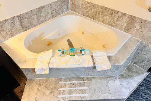 eine Badewanne mit Handtüchern auf einem Marmorboden in der Unterkunft Ocean Paradise Hotel & Resort in Ocean Shores