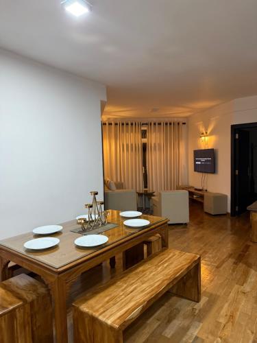 a dining room with a wooden table with plates on it at Nomentano Blue -Luxury Apartments- in Nuwara Eliya