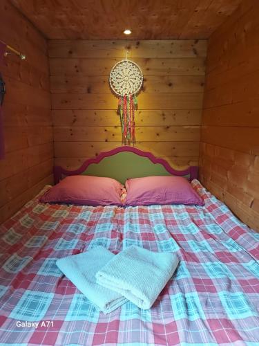 a bed in a wooden room with two pillows on it at Le Repaire de Mitzerlé in Mitzach